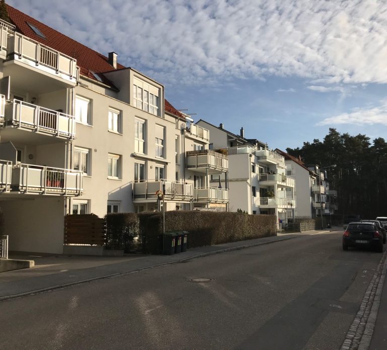 Wohnhäuser mit Balkonen und hellen Fassaden am Weißensee